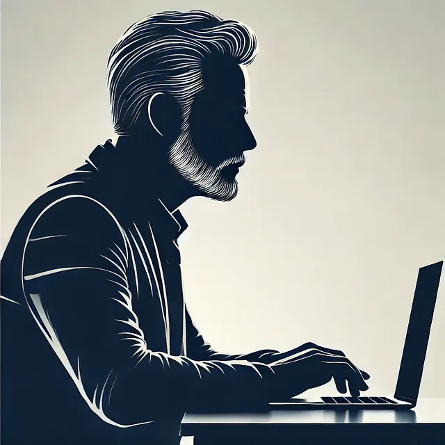 A silhouette of a seasoned techy at his laptop